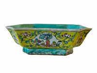Full side view showing the yellow ground and floral hand painted decoration on the footed dish.