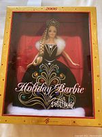 Front view of 2006 Holiday Barbie in box showcasing detailed black dress with gold and jewel tone embroidery and white faux fur accents.