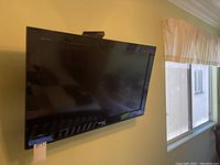 Wall-mounted black 32 inch Sony Bravia TV, visible Sony logo and wall bracket.
