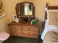 Full front view of antique wooden dresser with mirror, showing six drawers and carved detail on the top drawer area.