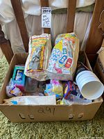 Shot of box filled with various McDonald's Happy Meal collectibles and promotional materials showing paper bags of Disney Pocahontas and Hot Wheels along with some plastic cups and unopened toy packages.