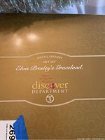 Top view of the box lid showing the gold background with printed text indicating a special edition gift set of Elvis Presley's Graceland from Discover Department.