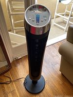 Full view of the Honeywell QuietSet tower fan approximately 39 inches tall, black with chrome accents, standing on circular base.