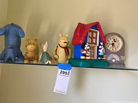 Shelf with figurines of Winnie the Pooh characters and Mickey and Minnie Mouse house clock and vintage Mickey Mouse clock.