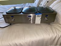 Overall front view of the Nostalgia electric food warmer showing three trays with glass lids and control dials.