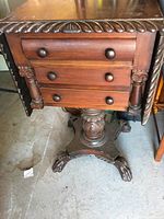 Frontal close-up showing carved rope-edge top, three drawers with round knobs, turned supports
