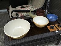 View of all bowls and decorative items on a glass table outside with chairs.