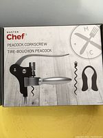 Photo of the Master Chef Peacock corkscrew box showing the product and included stopper, indicating lot contents and condition.
