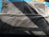 Grey soft fabric, folded and laid out, showing texture and medium grey color.