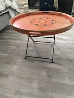 Full view of the table with removable wooden tray on black metal stand in a living space