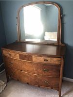 Full view of the dresser with attached arched mirror showing shape and finish.