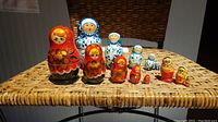 Photo of three sets of Russian nesting dolls with red and blue patterns on a woven surface.