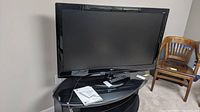 Front view of LG 47-inch plasma TV on black curved stand with remote and manuals.