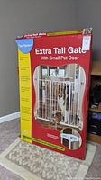 Full front view of the original boxed pet gate showing branding, product name, and image of gate installed with dog and cat.