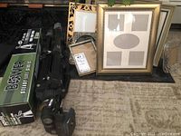 Photo showing the two tripods, one boxed Bower 52 and one SLIK V212, alongside multiple picture frames of varying sizes and styles.