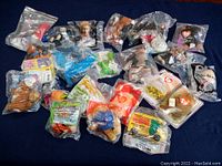 Lot of 23 vintage sealed toys in original plastic packaging, assorted variety of characters and themes.