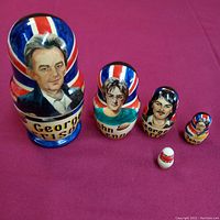 Photo of all 5 nesting dolls in descending size order, clearly showing portraits of George Harrison and John Lennon with British flag motif.