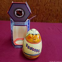 Wooden wobble doll showing front with Rangers logo and player depiction, next to its open hexagonal shaped original Stanka box with NHL logo.