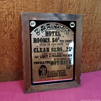 Wood framed mirrored sign with vintage text advertising hotel rooms and Wolfschmidt Vodka brand.