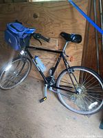 Full side view of Bridgestone CB-1 hybrid bike, showing frame, wheels, and accessories including blue handlebar bag and water bottle.