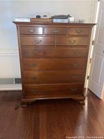 Full front view showing three small upper drawers and four larger lower drawers with brass bail handles