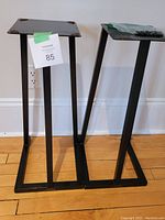 Two black steel Target Audio speaker stands side by side showing height and construction.