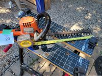 Photo showing the full length of the hedge trimmer blade with a measuring tape indicating approximately 13 inches.