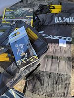 Full view photo showing agility ladders in black bags labeled U.S. Army, SKLZ Swift chute boxes, yellow jump bars, and Easton black bag with mesh pockets.