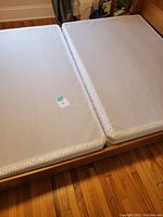 Two split queen box spring pieces side by side, showing the full surface area and top fabric material.
