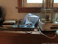 Photo showing the Soehnle food scale, electric hot plate, and Cuisinart food processor together on a counter by a window.