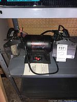Front view showing entire Craftsman 6 inch bench grinder with grinding wheels, power cord, and safety shields.