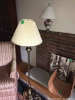 55 inch floor lamp next to a chair and fireplace with fabric shade and brass base