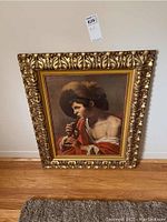 Full view of framed print depicting a man playing a flute with a large hat, dressed in red garment, positioned against a white wall.