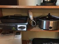 Fresco roasting pan on top of its box with Bamix hand blender and Crock-Pot slow cooker on shelf