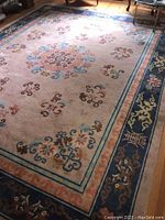 Full view of rectangular area rug with large central medallion and decorative border design in a living room setting.