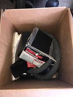 Box with vacuum accessories including hoses and nozzles, some branded Genie.