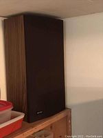 Photo of one Audio Reflex SB-400 speaker showing front fabric grill and wood side panel.