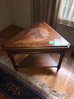 Top view of triangular wooden table showing wear and discoloration on surface.