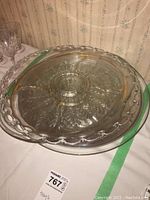 Glass serving tray with detailed starburst pattern and looped edges, used to show design and condition.