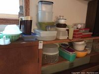 Wide view of multiple shelves filled with a variety of Tupperware and food containers in various colors and sizes.