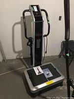 Full view of the VibaBody Slimmer exercise machine showing the platform base, upright handles, and control panel.