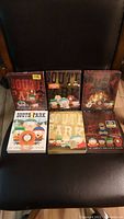 Six South Park DVD season sets shown on a chair, four sealed and two unsealed.
