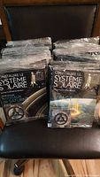 Multiple sealed packets of Construire Le Système Solaire model kit issues on chair