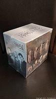 Photo of the sealed box set showing side with cast images and series title.