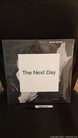 Front view of sealed vinyl album cover for David Bowie's The Next Day with white square label