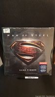 Front cover of sealed Man of Steel double LP vinyl showing Superman emblem and composer name.