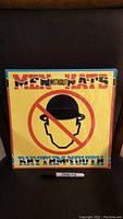 Front cover of sealed Men Without Hats Rhythm of Youth LP album, showing yellow cover with red no hat symbol.