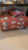 Front view of the Indian style elephant fabric ottoman with matching pillow on top.