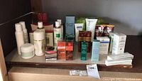 Wide view of various skincare bottles, tubes, creams, and boxed products arranged on shelf.