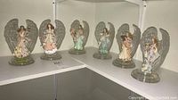 Photo showing all six Bradford Exchange collectible angels arranged on white shelves, revealing full set and conditions.